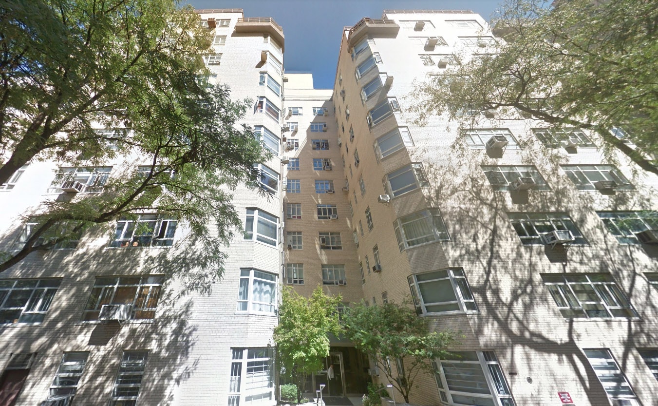 Well-lit living room with couch, chair, lamp, and art