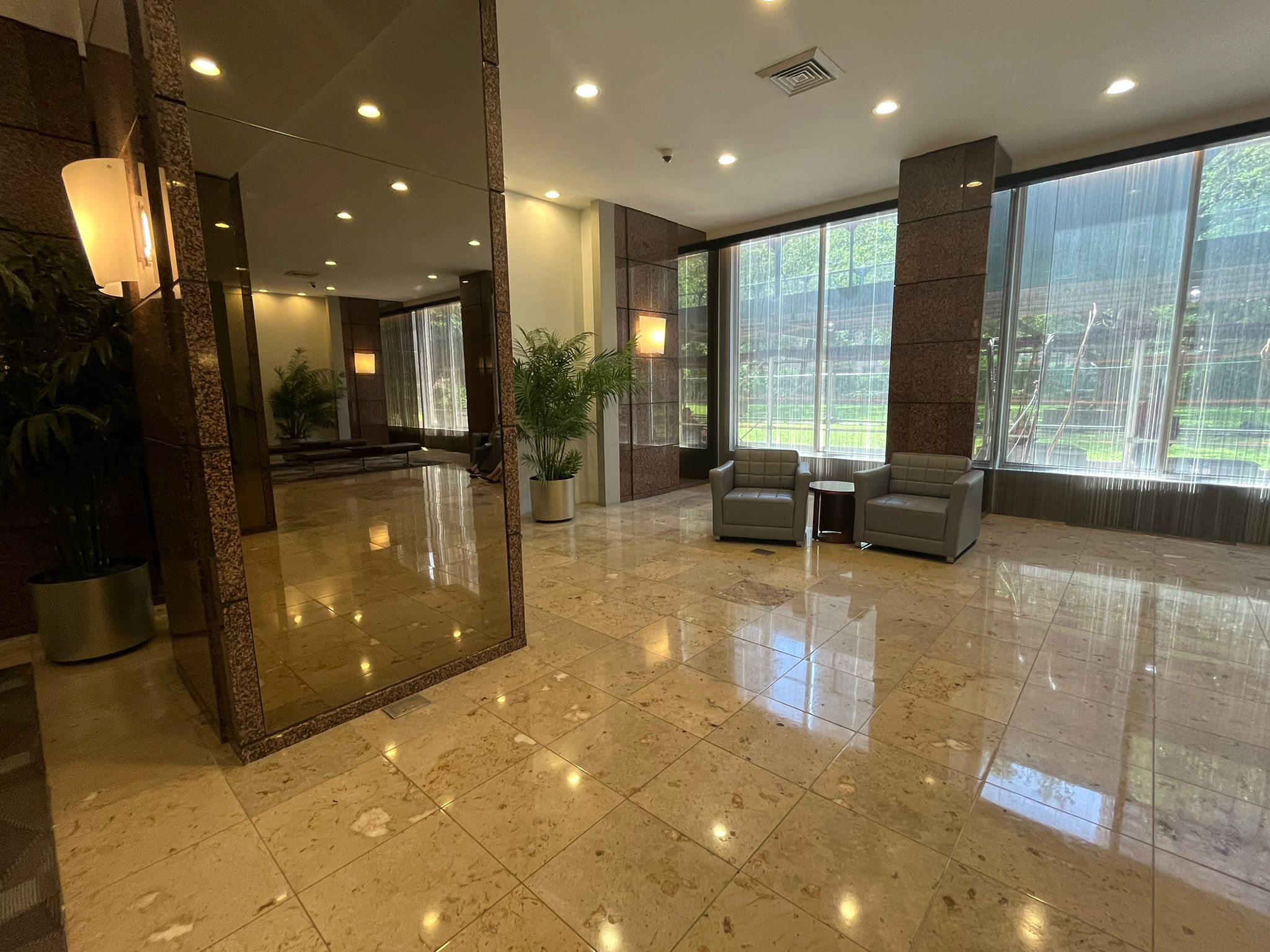 Well-lit hardwood floor with a comfortable couch and a stylish lamp